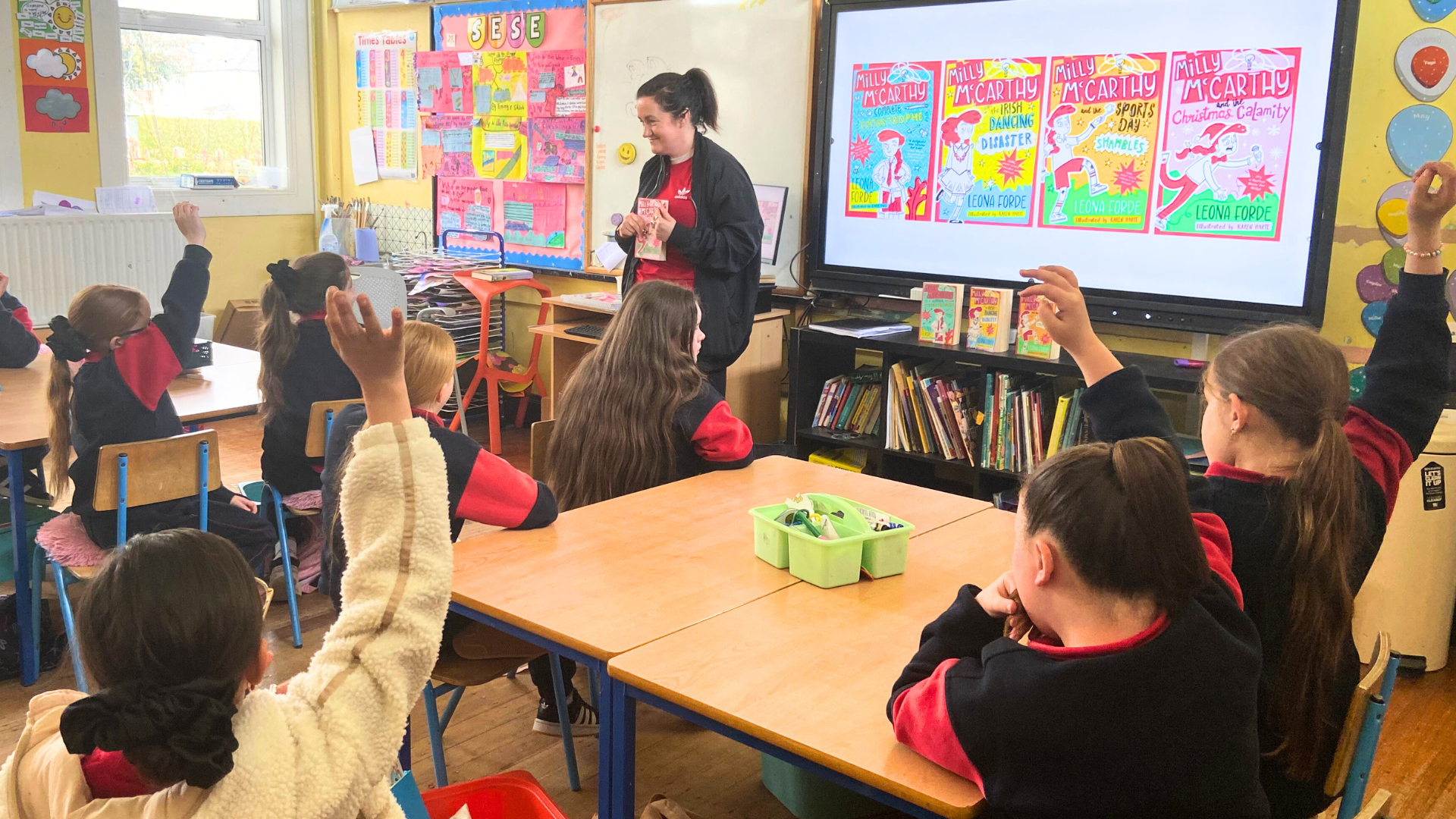 Children in classroom listening to an author give a presentation