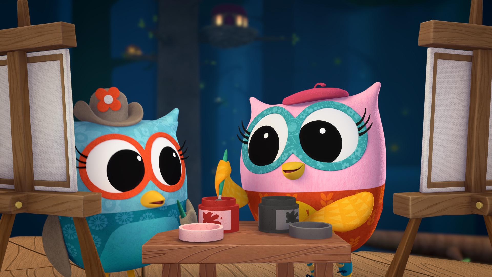 Two owl characters painting at easels with jars of colorful paint on a table in a nighttime forest setting.