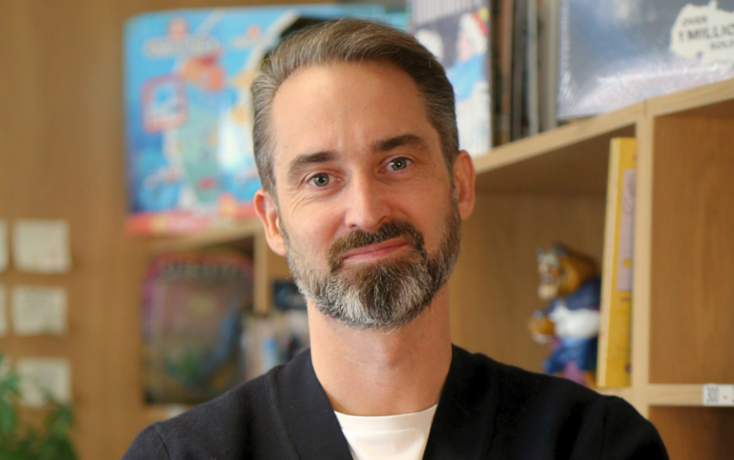 A photo of James Stacey, bookshelves in the background.