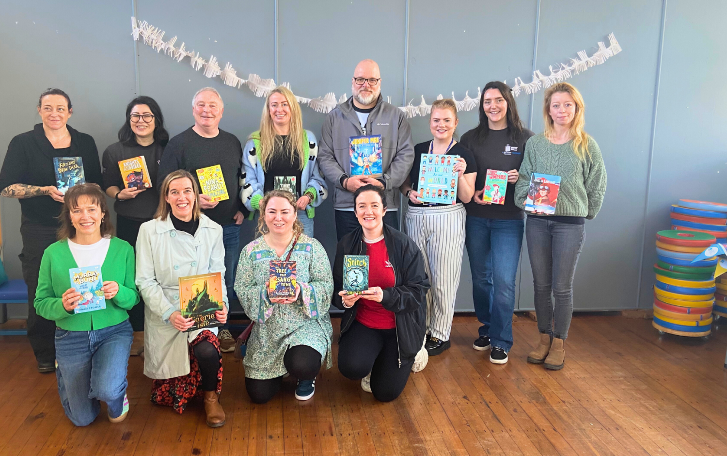A group photo of several people in front of the Bookbag book display