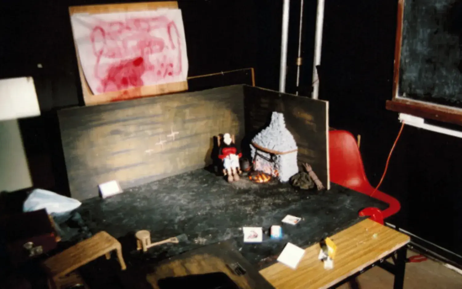 Small stop-motion set on a table, featuring a miniature fireplace, furniture, and a figure of Peig Sayers.