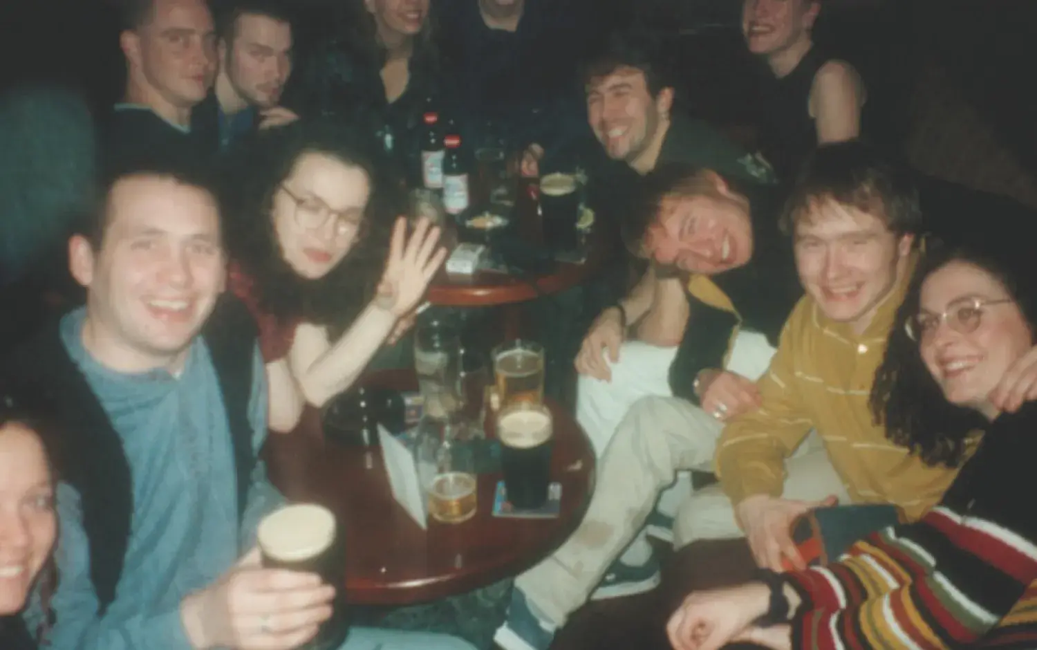 Group seated around small tables in a pub, with several glasses of beer and soft drinks visible.