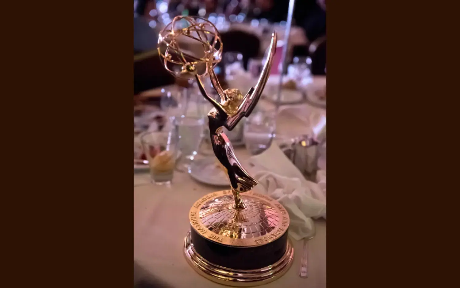 Emmy Award trophy displayed on a banquet table.