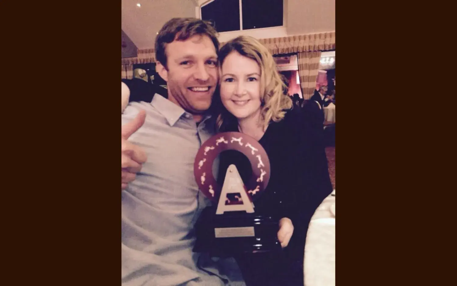 Two people seated at a table holding an Irish Animation Award at the ceremony.