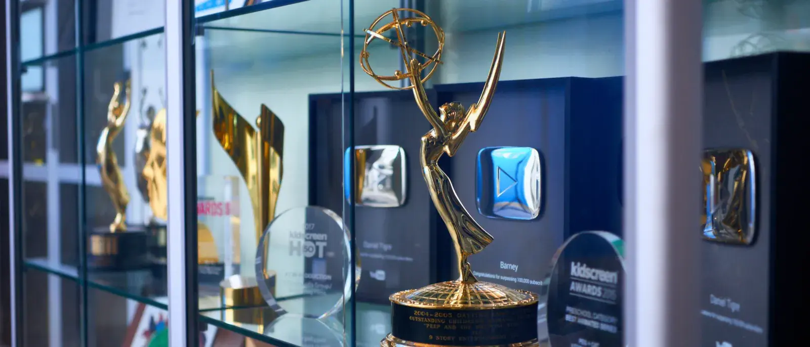 A close up of awards statuettes in a glass awards case