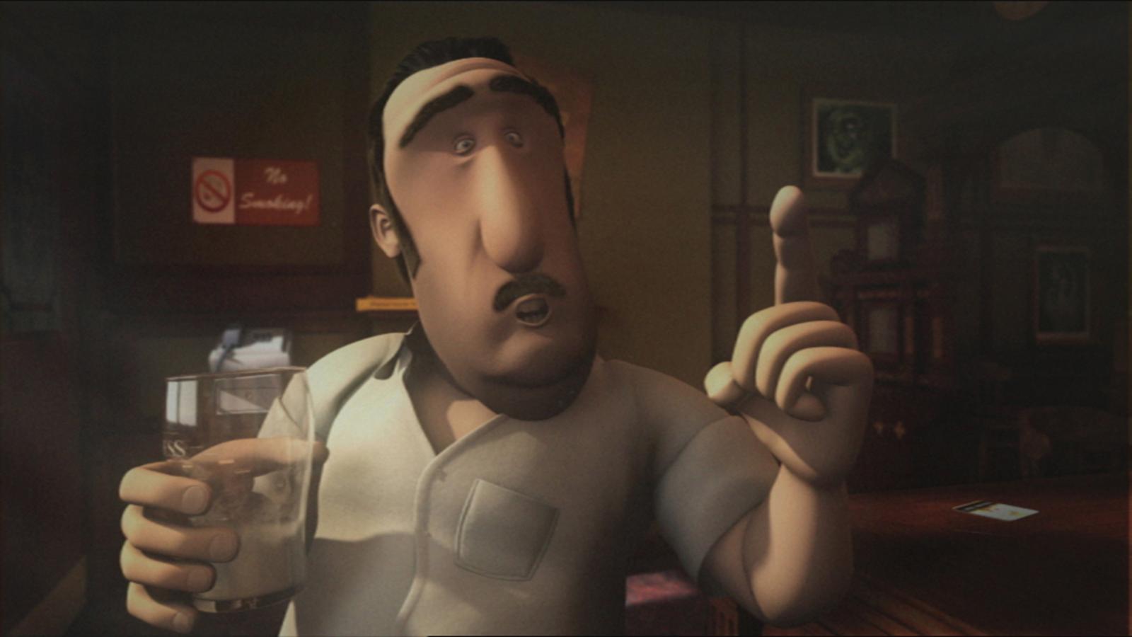 Bartender Denny holding a pint glass and gesturing with his hand.