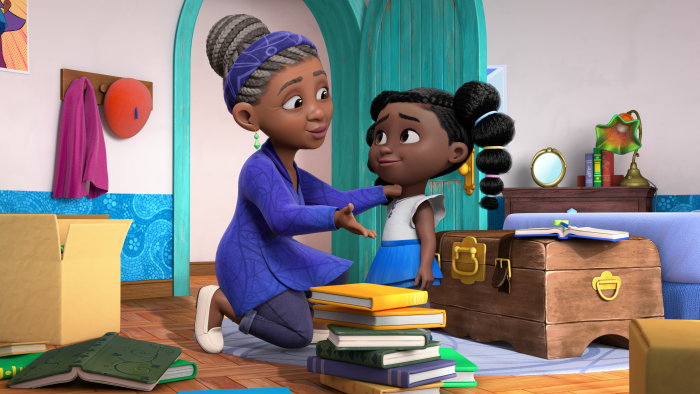 Dee and her grandmother in her room. Books are stacked on the floor in front of them.