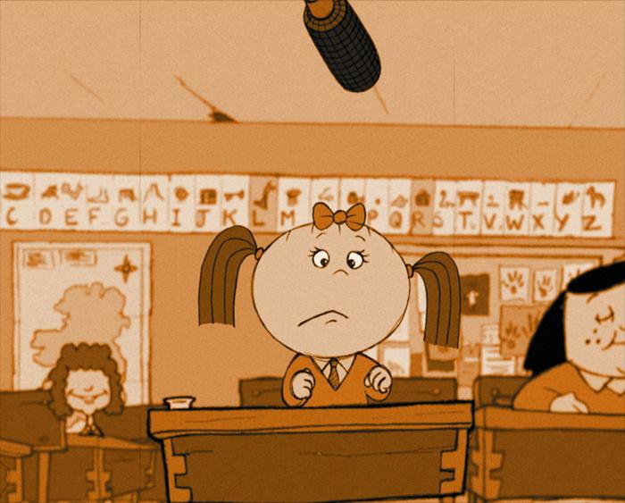 A classroom scene with a young student sitting at a desk looking up at a microphone hanging from the ceiling. Other students are visible in the background.