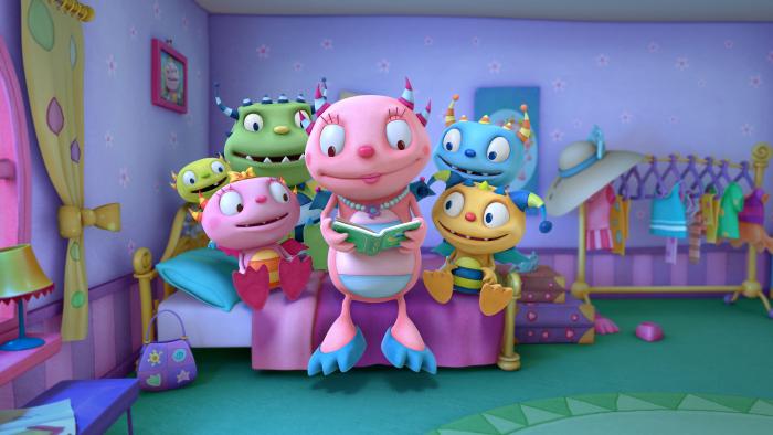 Henry and his family sitting around his mom on a bed while his mom is looking at a book